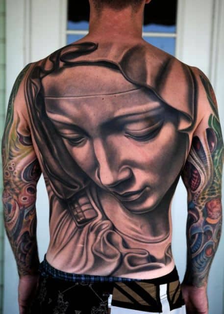 Tatuagem cobrindo as costas de um homem com o desenho com o rosto super detalhado da Virgem Maria olhando para baixo. 