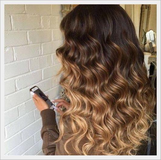 Californiana em cabelo cacheado castanho.