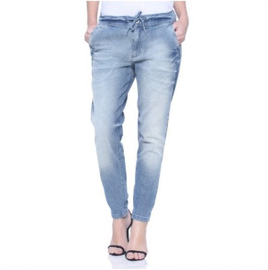 Calça jogger jeans combinada com blusa ranca e sandalia preta de tiras.