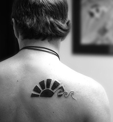 Tatuagem nas costas de um homem com o desenho do sol oriental formando três ondas minimalistas. 