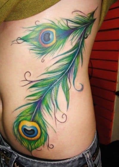 Modelo de tatuagem de pavão na barriga colorida nas cores verde, amarelo e azul.