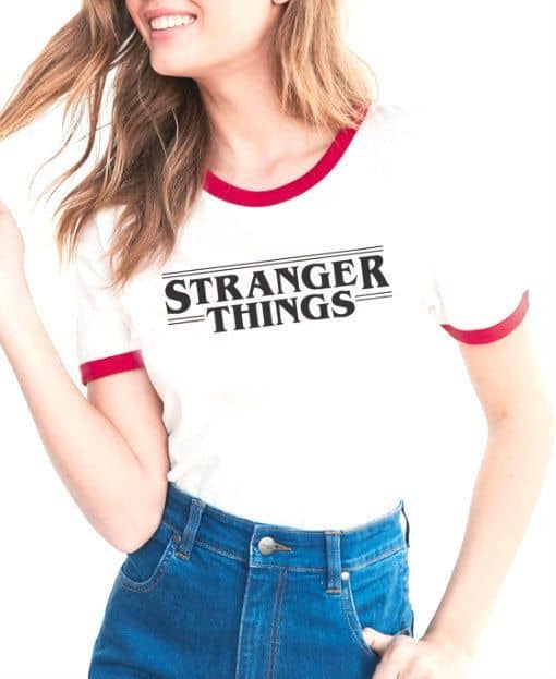 Mulher com camiseta da série Stranger Things e calça jeans.