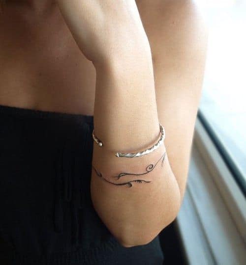 Mulher com tatuagem bracelete feminino.