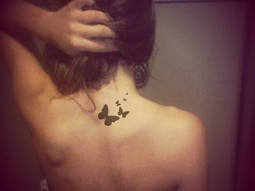 Tatuagem de borboleta preta nas costas.
