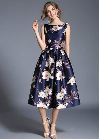 Modelo usa vestido azul escuro florido.