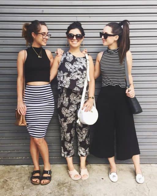 Foto de look de três blogueiras, com uma delas usando saia lápis listrada e cropped.