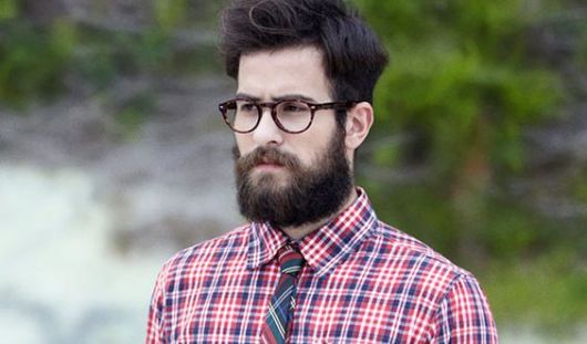 Homem com barba e camisa xadrez.