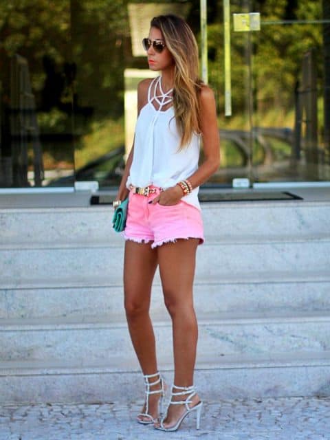 modelo usa short rosa com blusa branca e sandalia.