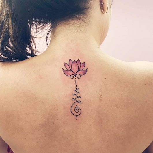 tatuagem flor de lótus nas costas nas cores cor de rosa.