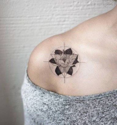 tatuagem flor de lótus preta e traço fino em círculo.
