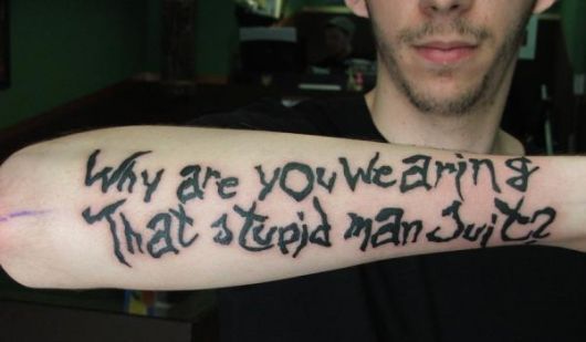 Tatuagem com frase inspirada no clássico filme Donnie Darko: "Por que você está vestindo essa fantasia estúpida de humano?"