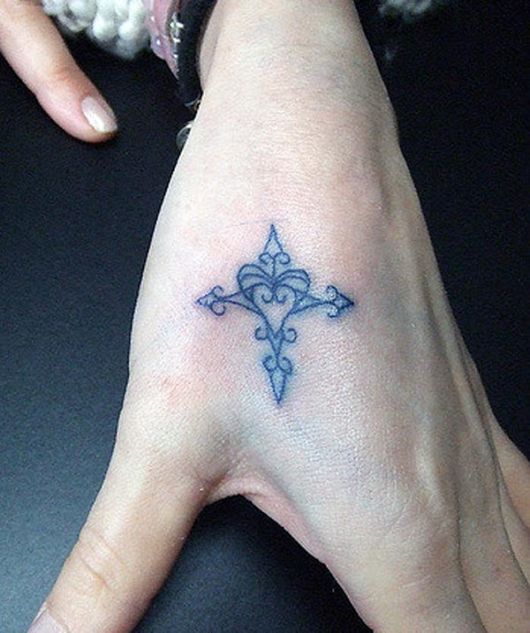 Tattoo de cruz com coração na mão