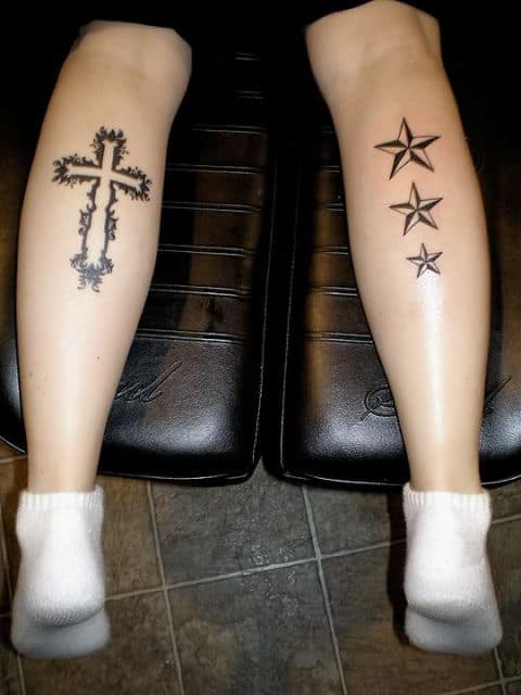 Tattoo de cruz em uma panturrilha e de estrelas na outra