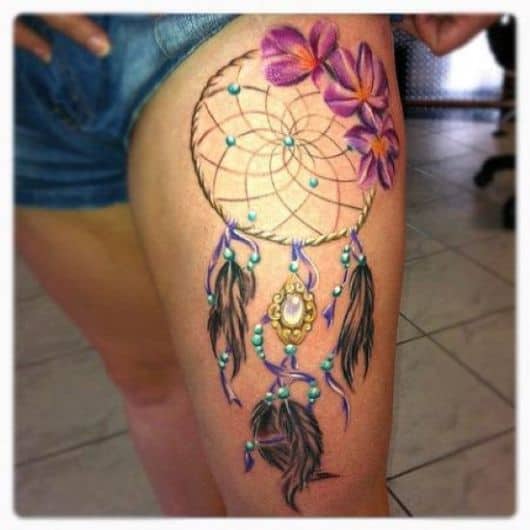 tatuagem filtro dos sonhos na coxa com cores e flores