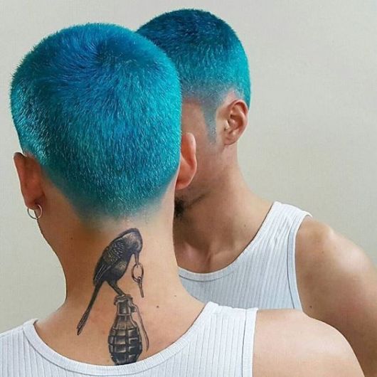 Homem de costas, com cabelo azul turquesa raspado 