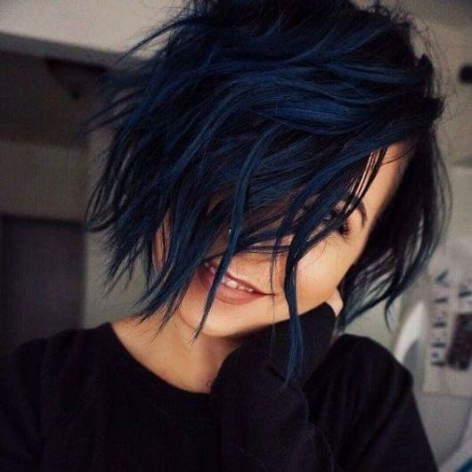 Mulher com cabelo curto azul escuro.