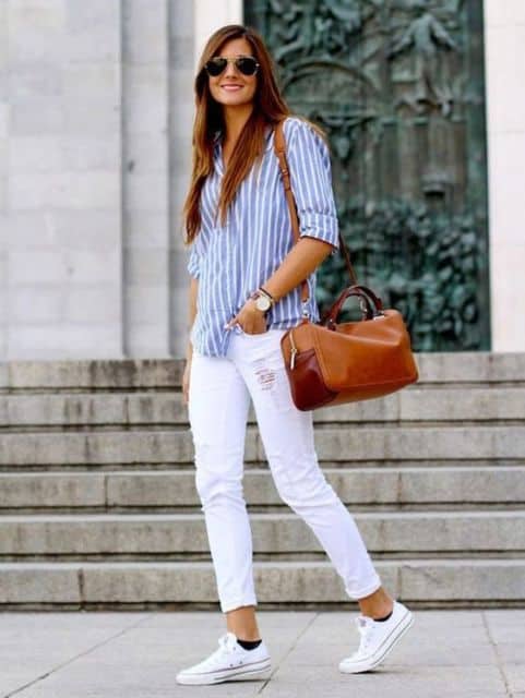 modelo usa camisa estampada azul e calça branca com tenis na mesma cor.