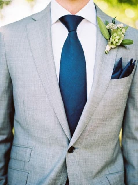 Lenço azul combinando com a gravata azul e uma flor 