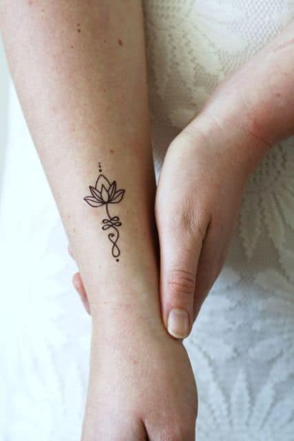 tatuagem simples de flor de lótus no pulso.