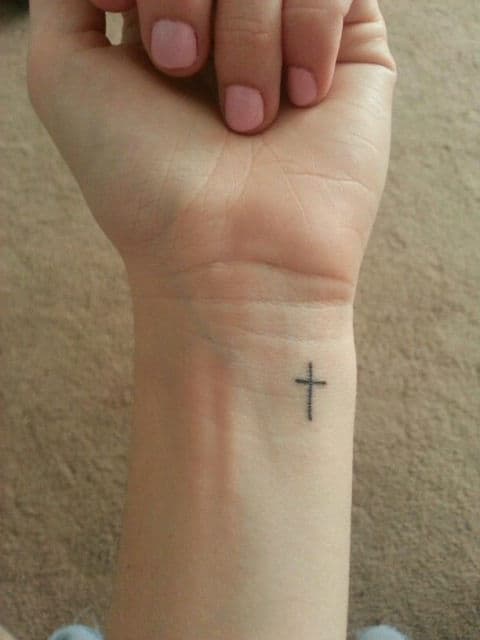 tatuagem delicada de cruz.