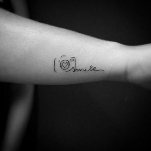 tatuagem escrita com a palavra sorria.