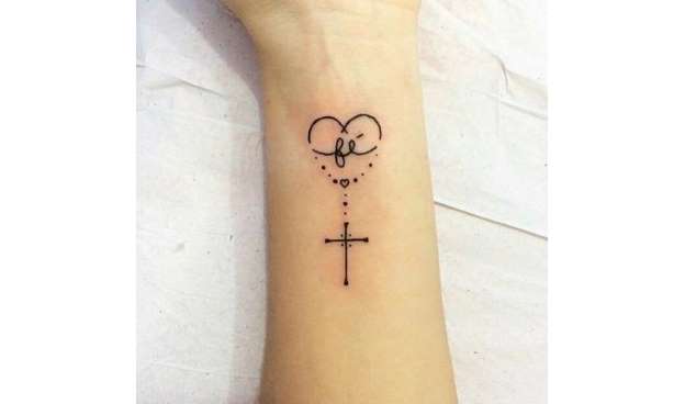 tatuagem escrita fé com detalhe de cruz e coração pontilhado.