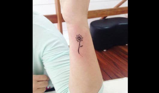 tatuagem de flor no pulso.