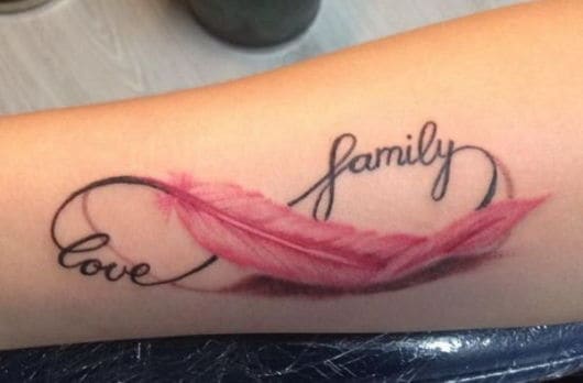 Amor e família nessa tatuagem do infinito com pena colorida