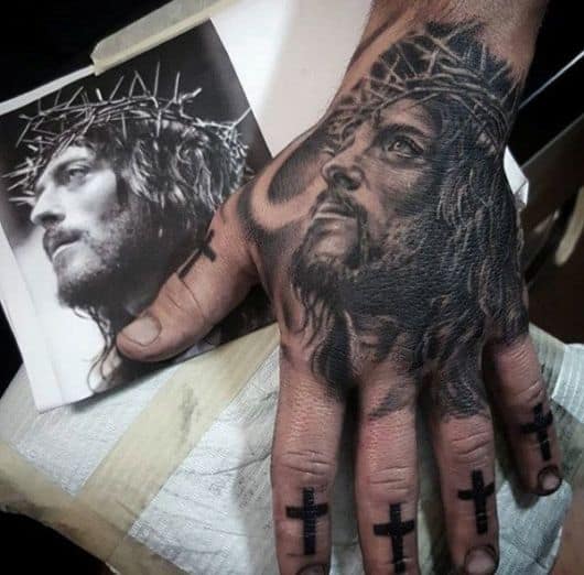 tatuagem na mão masculina religiosa