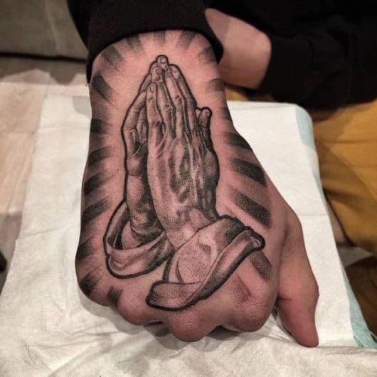 tatuagem na mão masculina religiosa