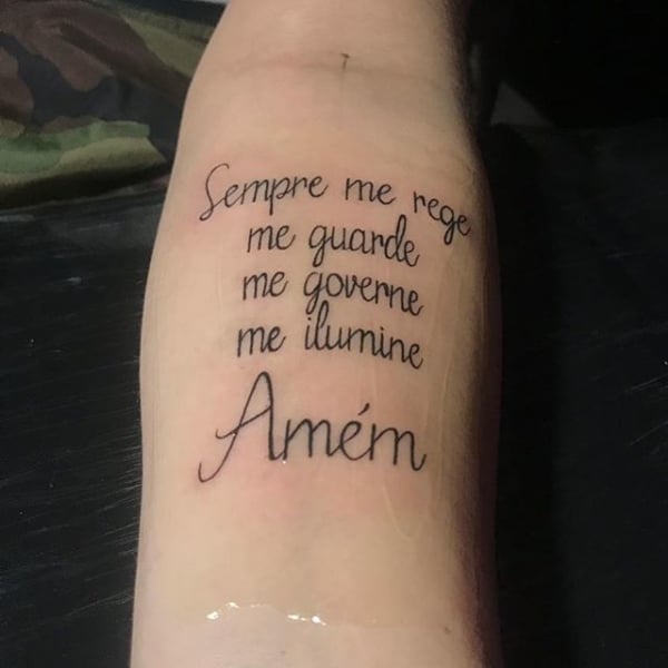 tatuagem de frases no braço masculina com inspiração religiosa