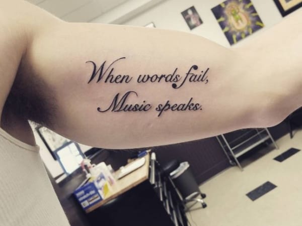 tatuagem de frases no braço masculina de música