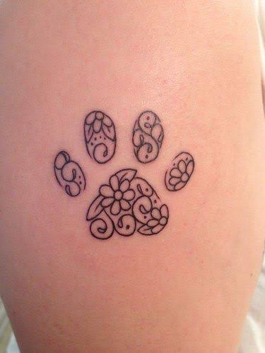 tatuagem de pata de cachorro pequena e delicada com flor