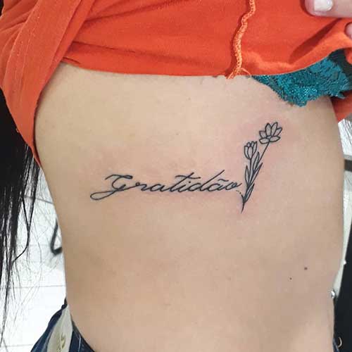 tatuagem gratidão na costela feminina