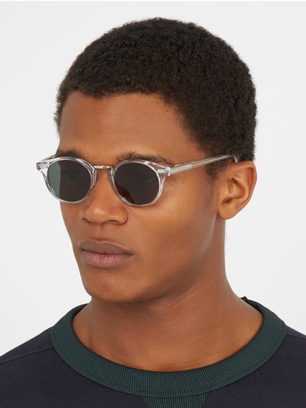 homem com óculos de sol redondo e transparente
