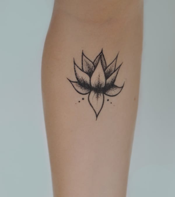 Flor de lótus pequena tatuada no braço