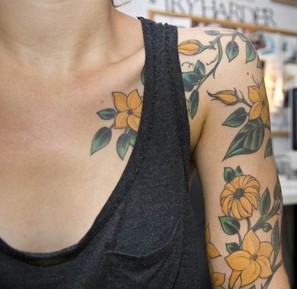 Flores amarelas tatuadas no ombro e braços