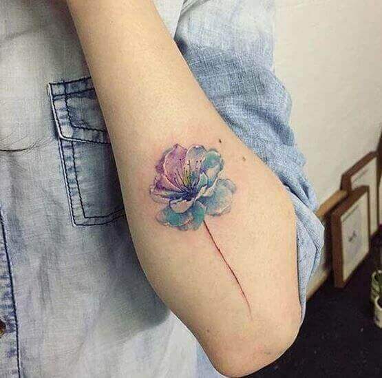 Tatuagem de flor no braço em aquarela