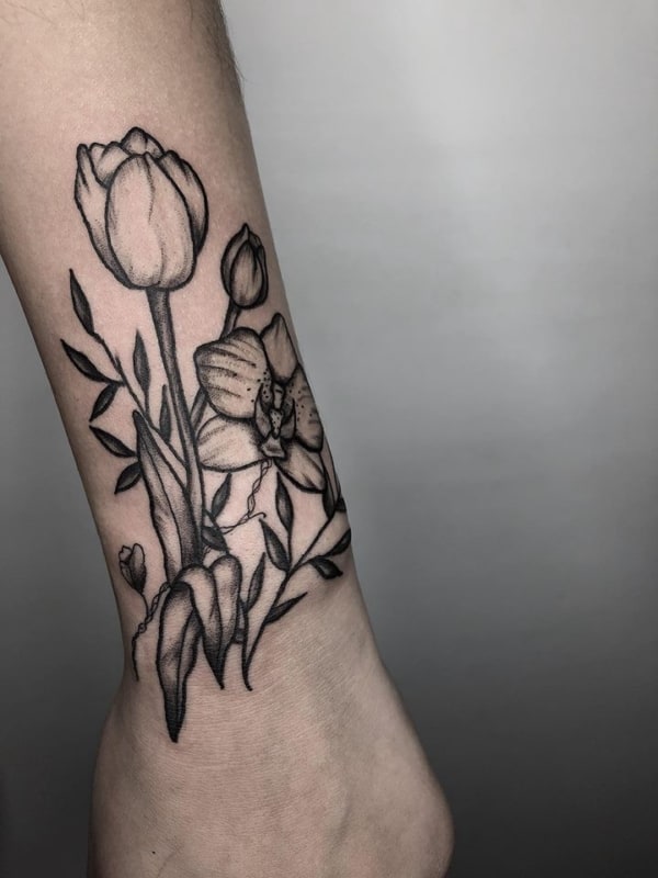 Tattoo preta e branca de flor no pulso