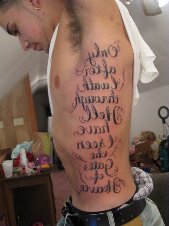 Tatuagem com escritos grandes na costela
