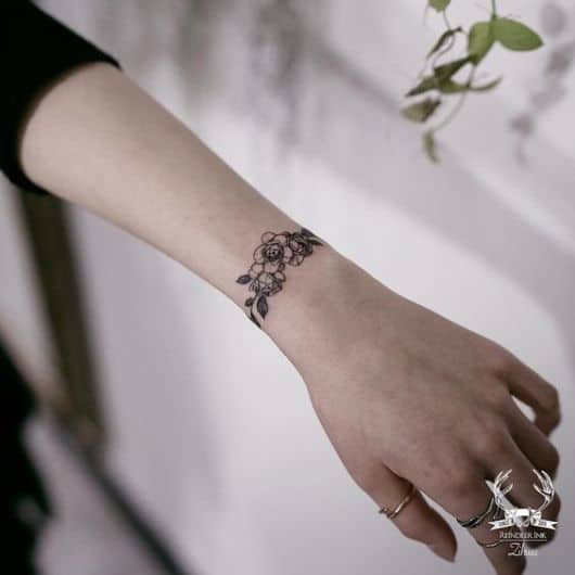 Tatuagem pequena de flor no pulso