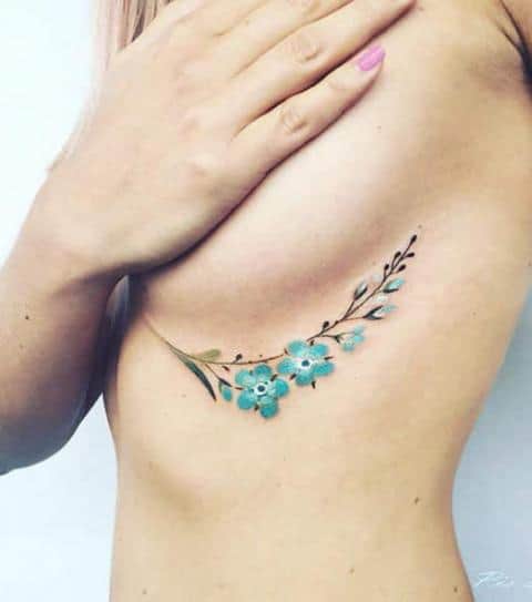 tatuagem embaixo dos seios de flores azuis