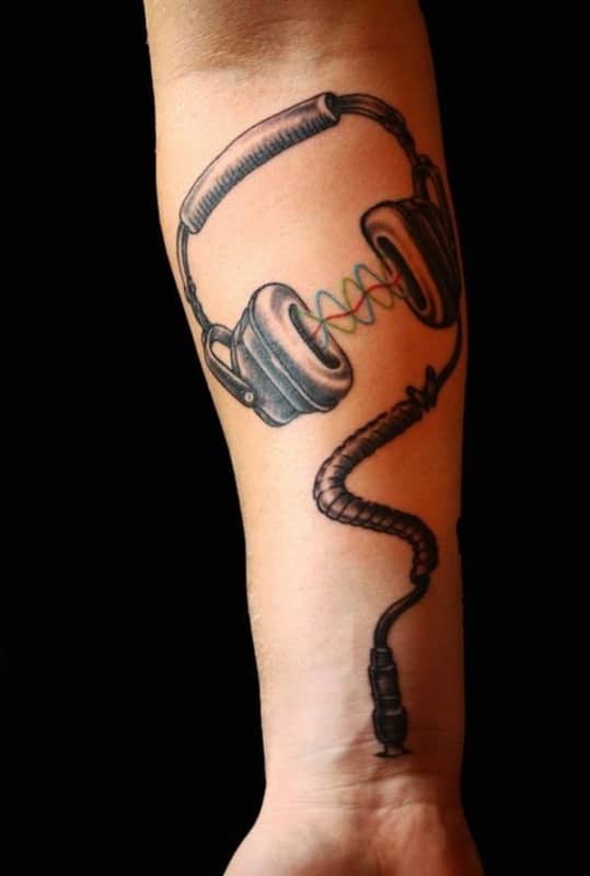 tatuagem de música no braço fones