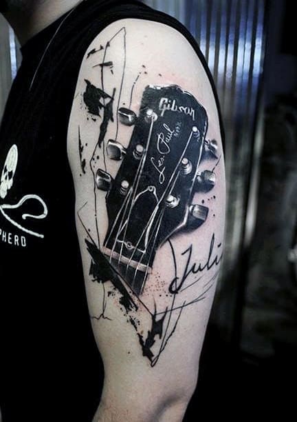tatuagem de música no braço violão