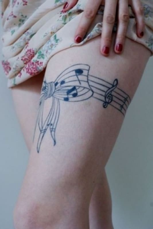 tatuagem de símbolo de música delicada