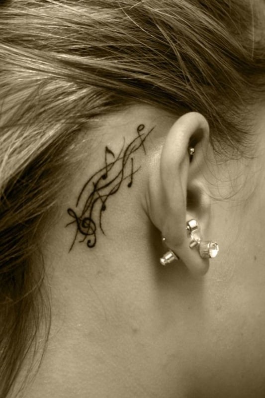 tatuagem de símbolo de música no pescoço