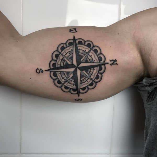 tattoo de bussola no biceps masculino