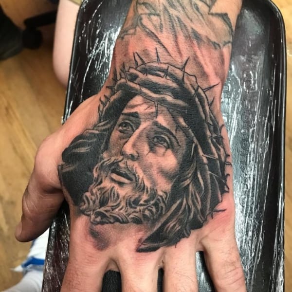 tatuagem grande de Jesus na mão