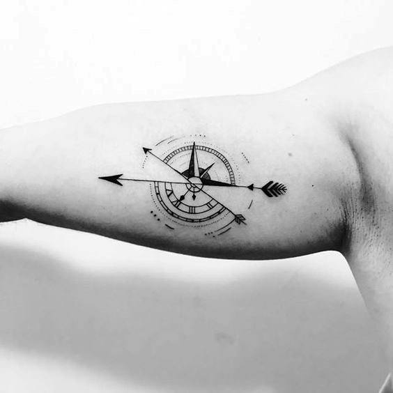 tatuagem no bíceps masculino bussola minimalista