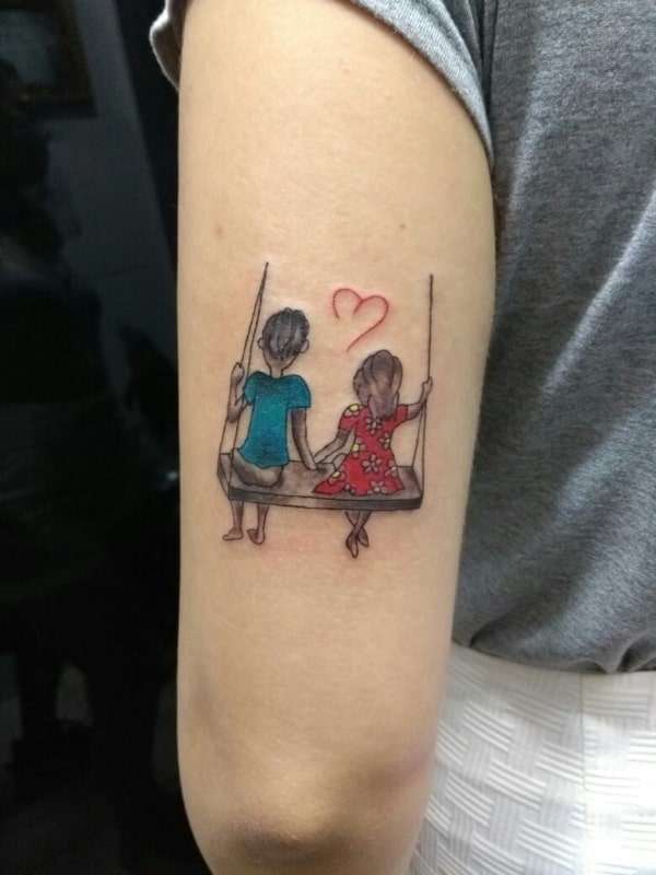 Tatuagem de bonequinhos para casal no braço
